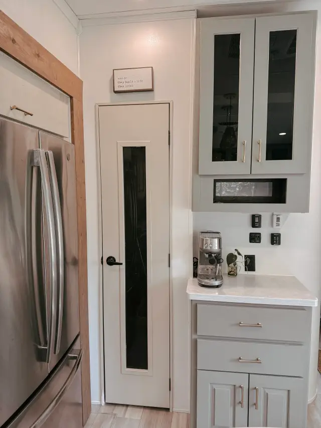 RV kitchen coffee nook with pantry door, glass cabinets and espresso machine.